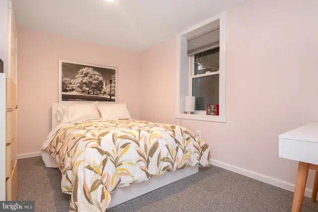 a bedroom with a bed and a painting on the wall