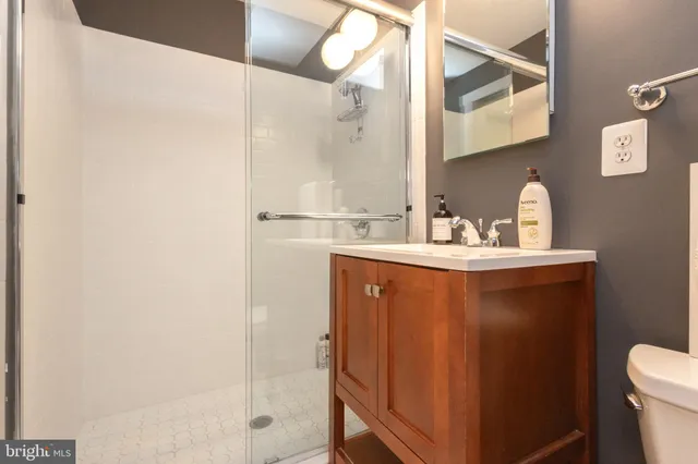 a bathroom with a sink a toilet and shower