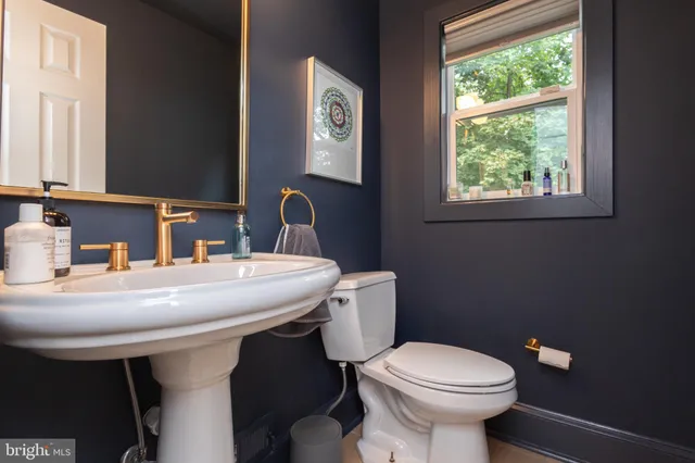 a bathroom with a sink a toilet and a mirror