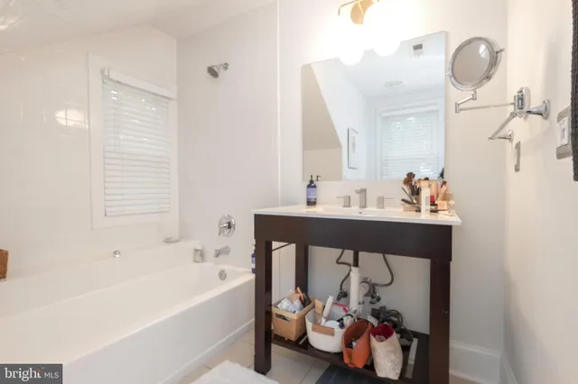a bathroom with a sink mirror and tub
