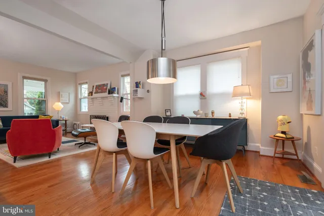 a dining room with furniture a chandelier and wooden floor