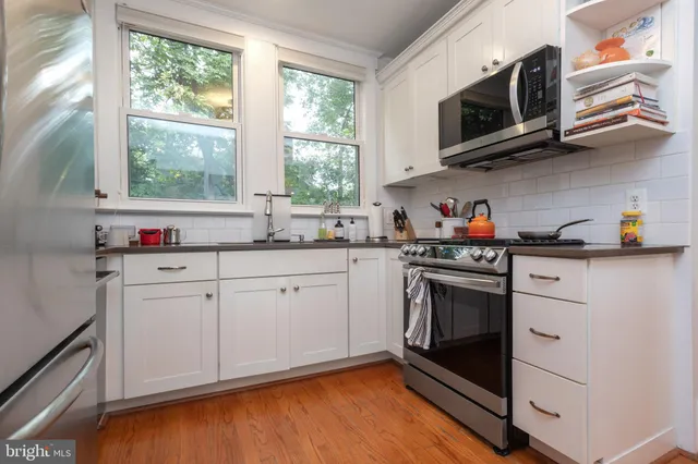 a kitchen with stainless steel appliances granite countertop cabinets sink and window