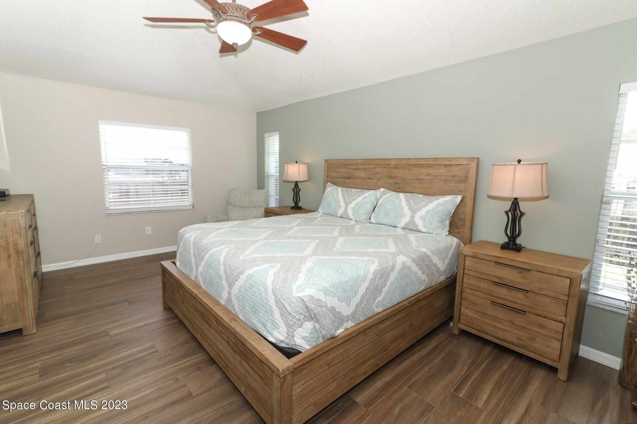 834 Egret Road Cocoa, FL 32926 - Photo 16 of 85 a bed sitting in a bedroom next to a window and a chandelier