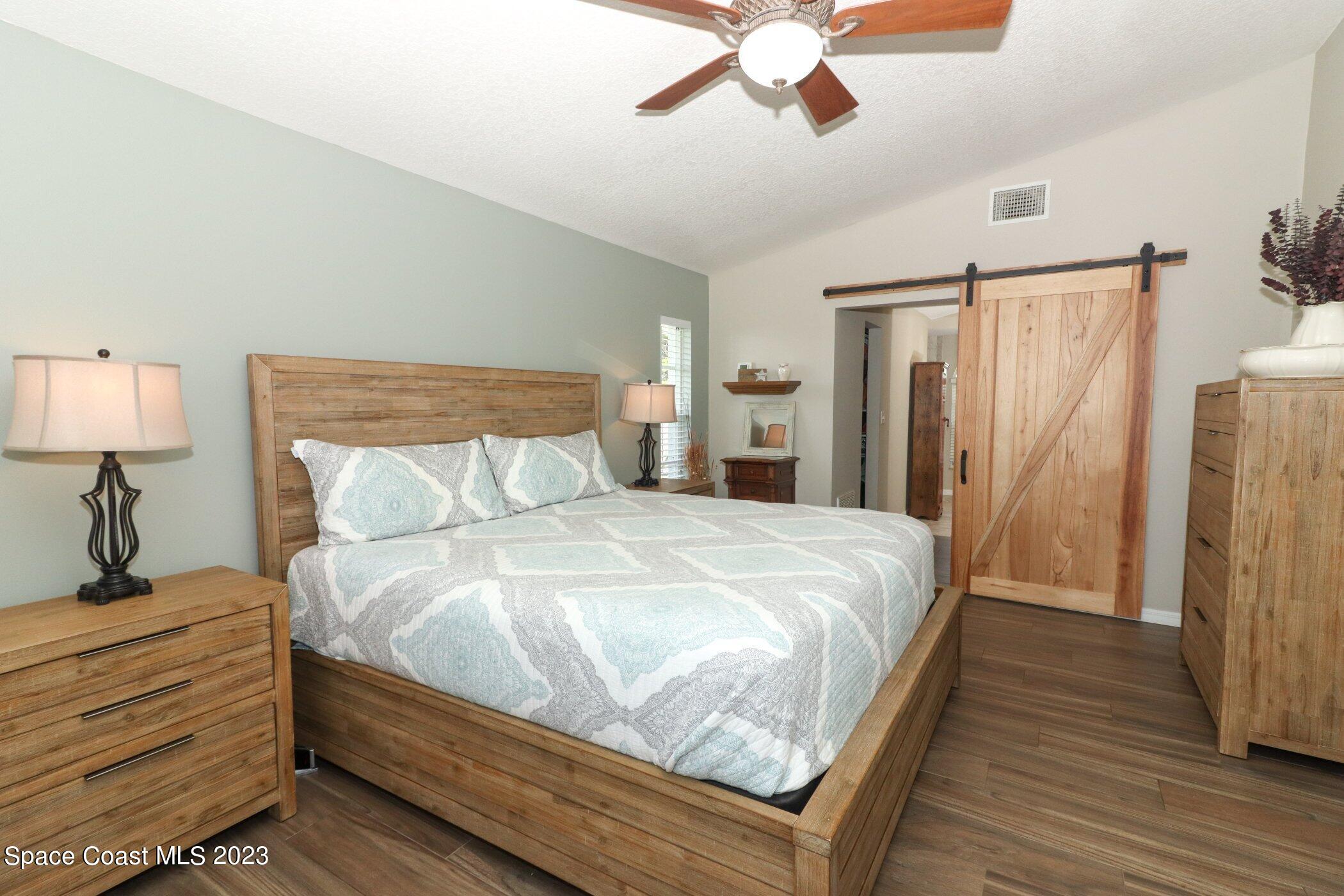 834 Egret Road Cocoa, FL 32926 - Photo 19 of 85 a bedroom with a bed and a chandelier