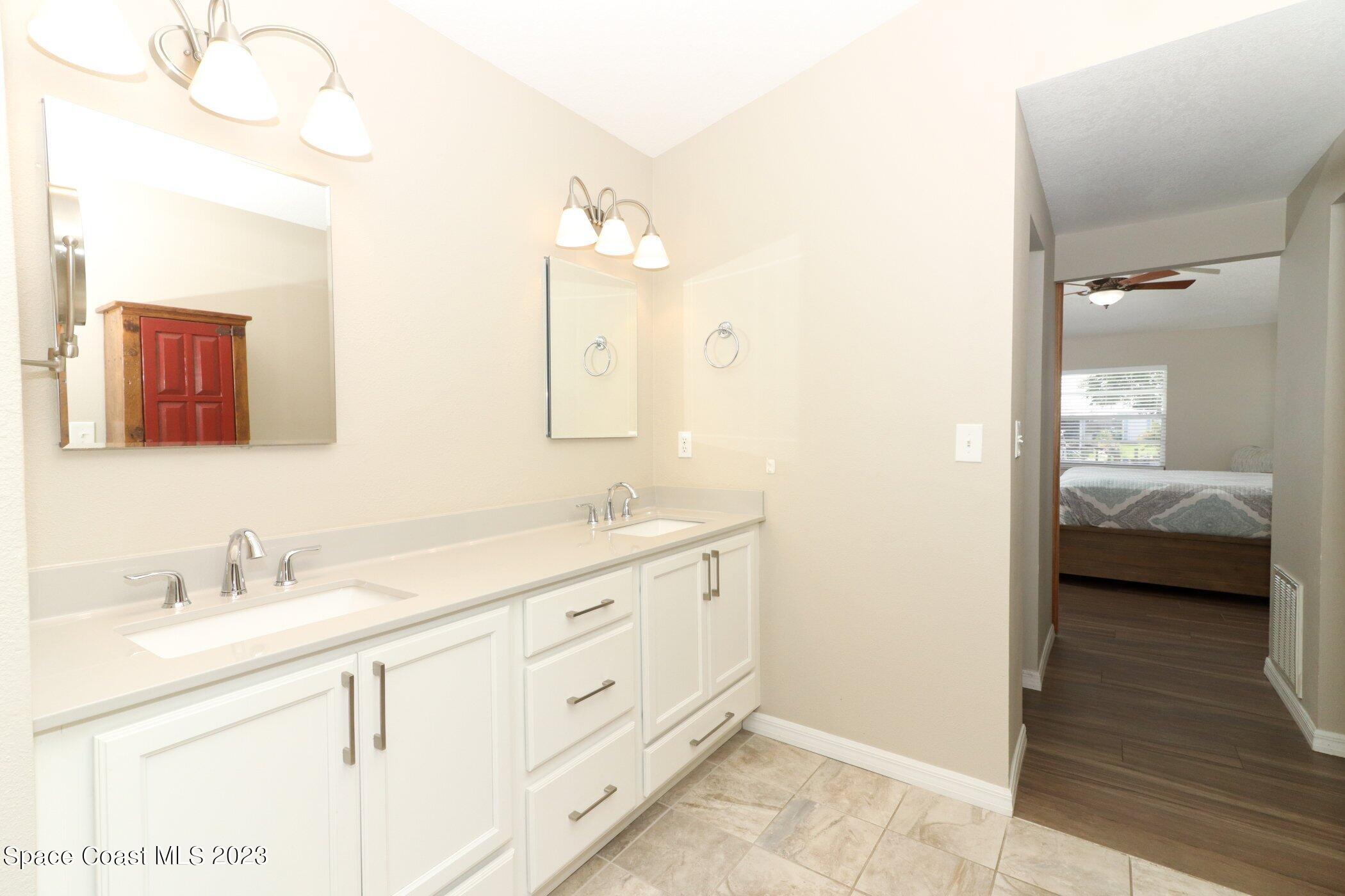 834 Egret Road Cocoa, FL 32926 - Photo 20 of 85 a en suite bathroom with a double vanity sink and a mirror