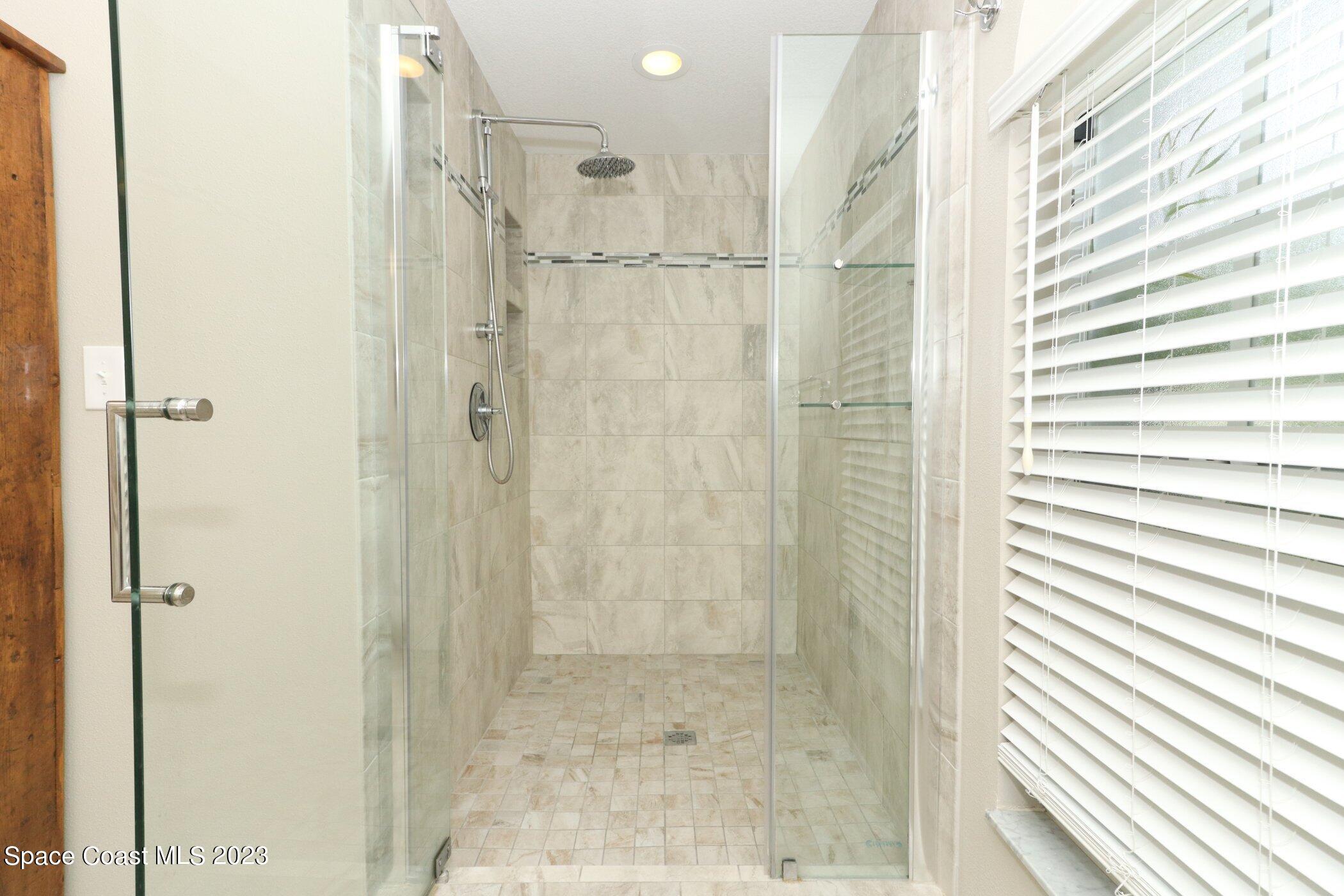 834 Egret Road Cocoa, FL 32926 - Photo 23 of 85 a bathroom with a shower and a glass door
