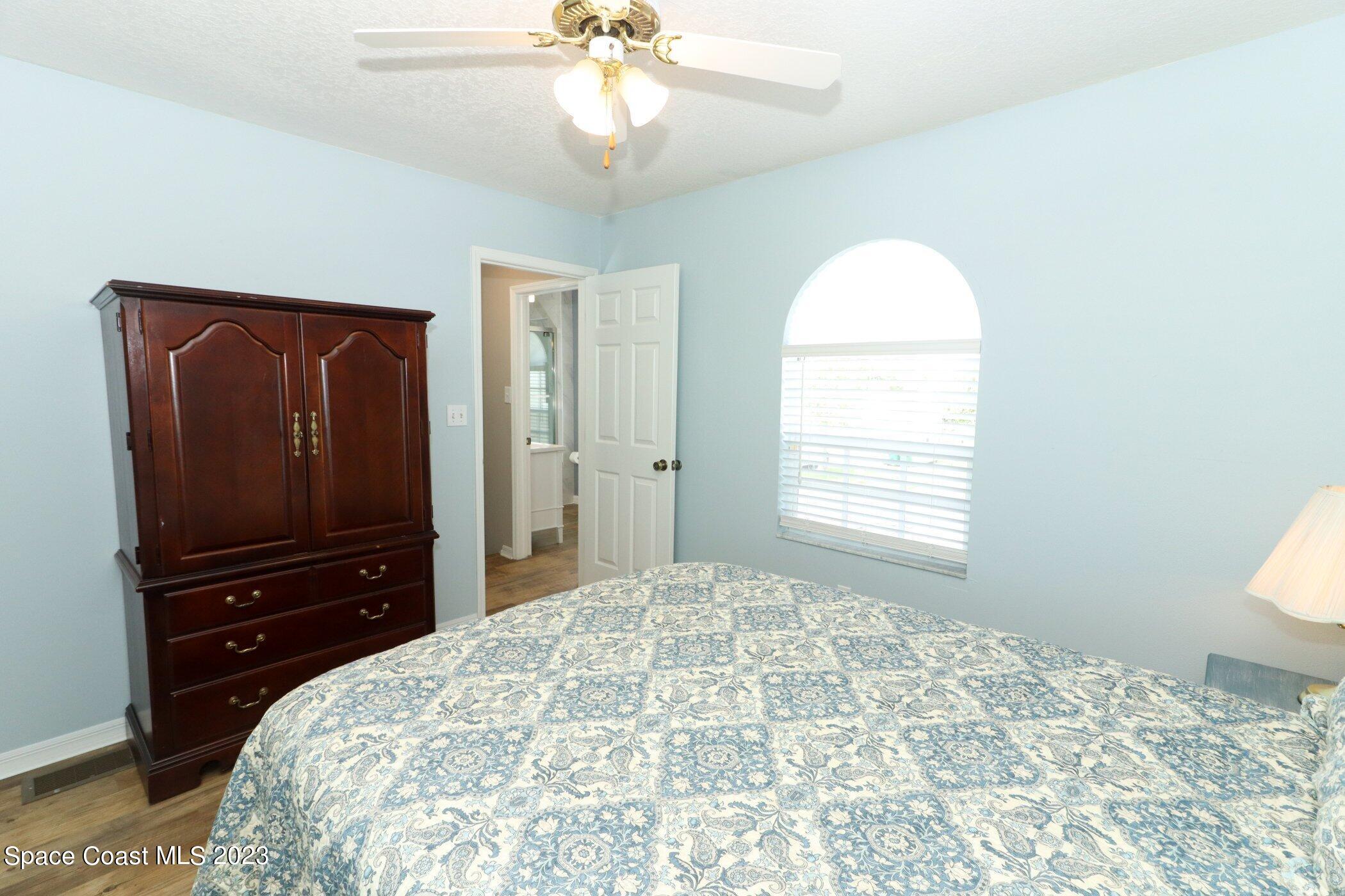 834 Egret Road Cocoa, FL 32926 - Photo 30 of 85 a bedroom with a bed and a flat tv screen on dresser