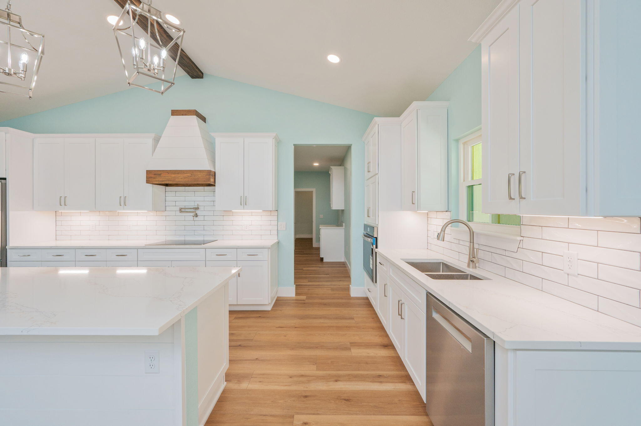 3504 Plympton Road Laurel Hill, FL 32567 - Photo 16 of 62 a large white kitchen with a large island oven a stove and a chandelier