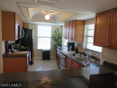3806 Guilford Road, Unit 101 Naples, FL 34112 - Photo 6 of 19 a kitchen with a stove a sink a refrigerator and a counter top space
