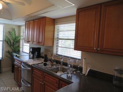 3806 Guilford Road, Unit 101 Naples, FL 34112 - Photo 8 of 19 a kitchen with granite countertop wooden cabinets a sink and a window