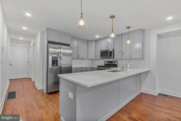 a kitchen with kitchen island a sink stainless steel appliances and cabinets