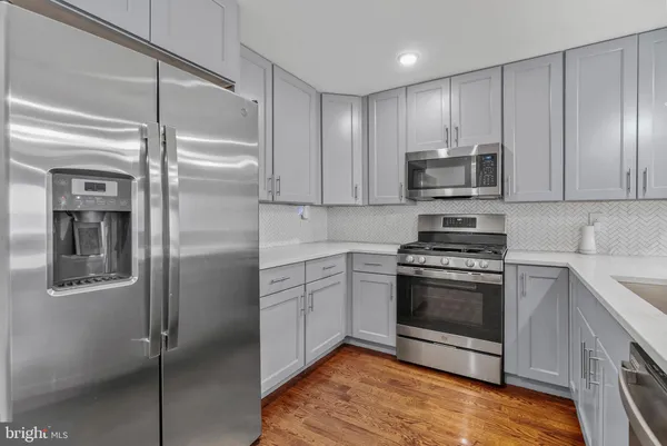 a kitchen with stainless steel appliances granite countertop a refrigerator and a stove top oven
