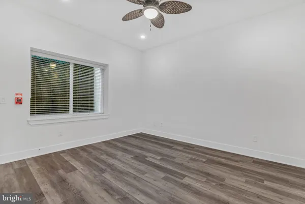 a view of wooden floor and a chandelier fan in a room