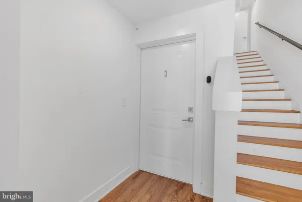a view of a hallway with wooden floor and entryway