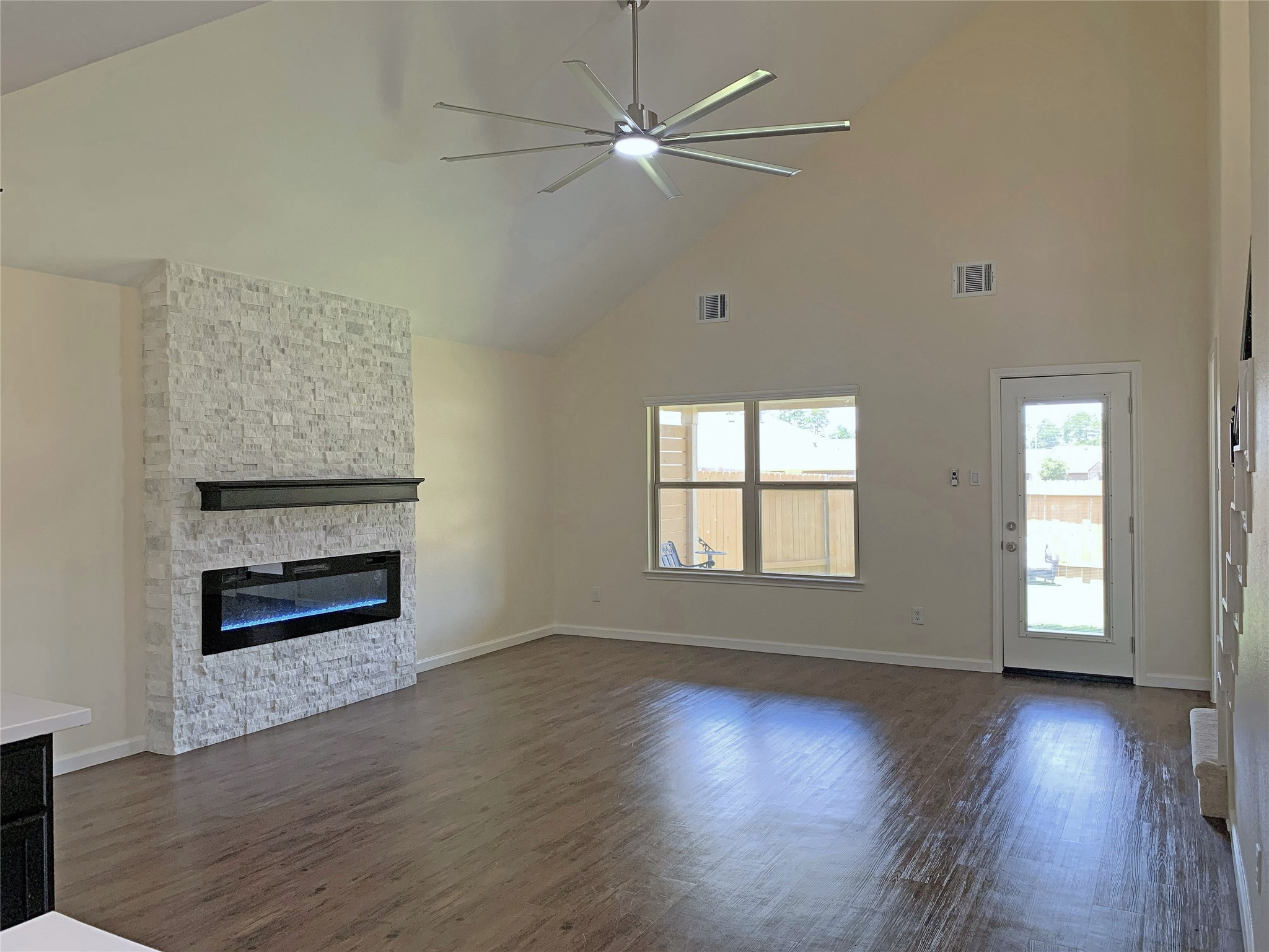 5612 Rainflower Terrace Lane Spring, TX 77389 - Photo 15 of 50 an empty room with wooden floor a ceiling fan and windows