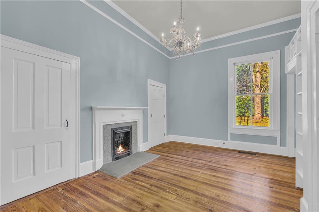 5921 Bostwick Road Bishop, GA 30621 - Photo 12 of 65 a view of an empty room with wooden floor fireplace and a window