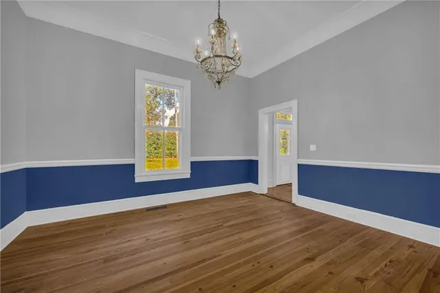 a view of empty room with window and wooden floor