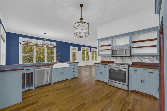 a kitchen with stainless steel appliances granite countertop a stove cabinets and wooden floor