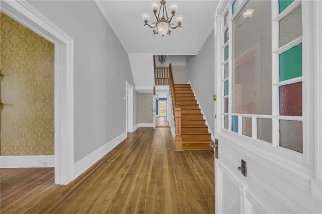 a view of a hallway with wooden floor and staircase