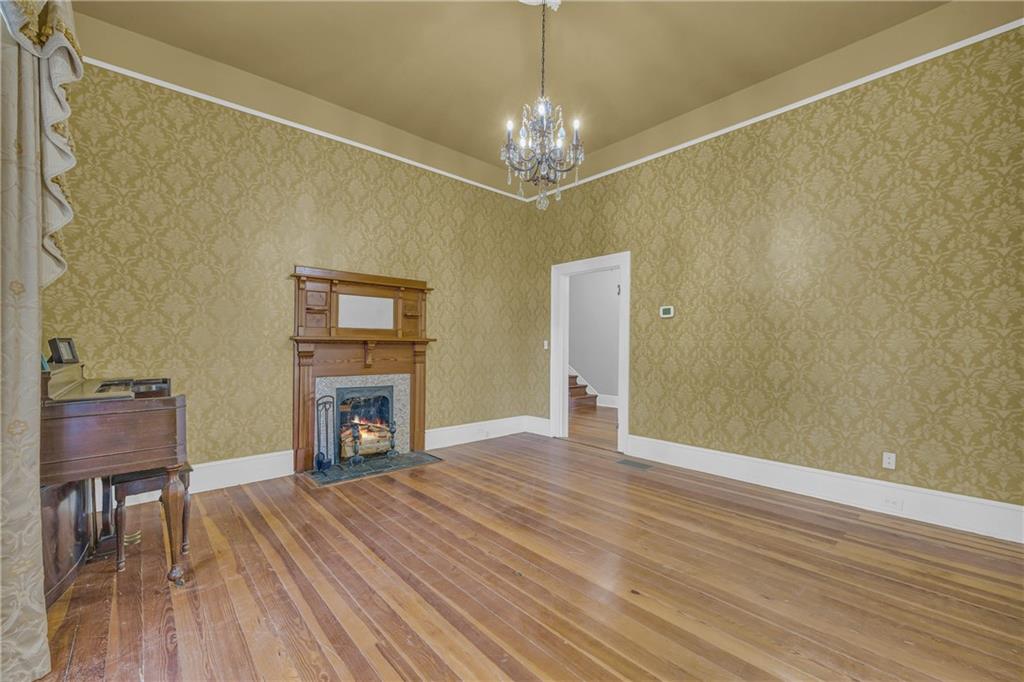 5921 Bostwick Road Bishop, GA 30621 - Photo 8 of 65 a view of an empty room with a fireplace and a chandelier