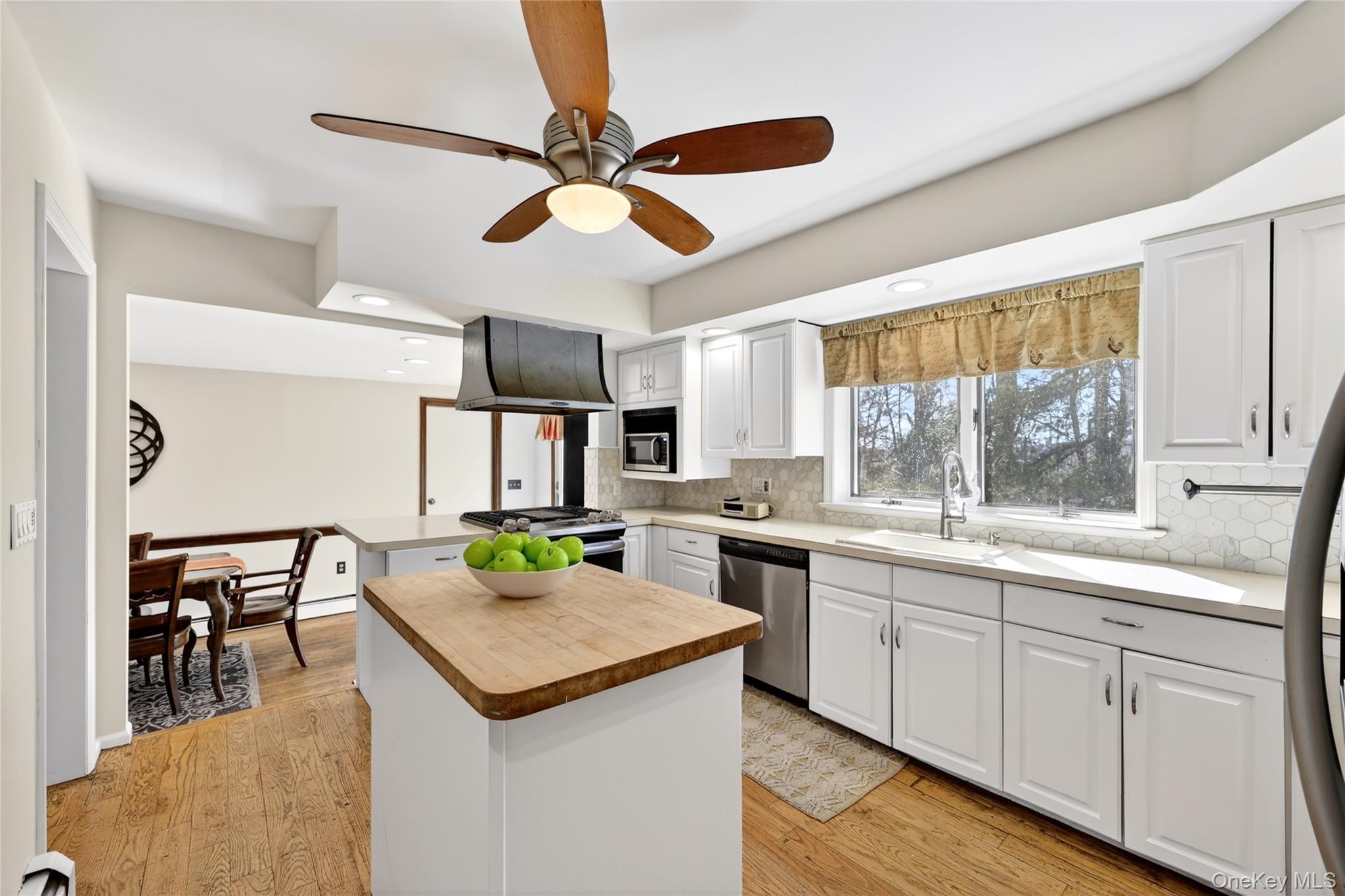18 Taylor Road Elmsford, NY 10523 - Photo 3 of 29 The kitchen features white cabinetry, a kitchen island with a wood countertop, and stainless steel appliances