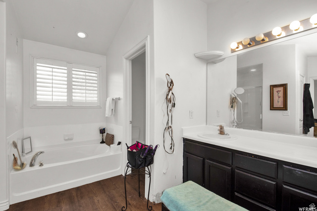 339 North Farm Mdw Road Farmington, UT 84025 - Photo 6 of 17 Bathroom featuring a built-in tub with chrome fixtures, wood-finish flooring, and white plantation shutters