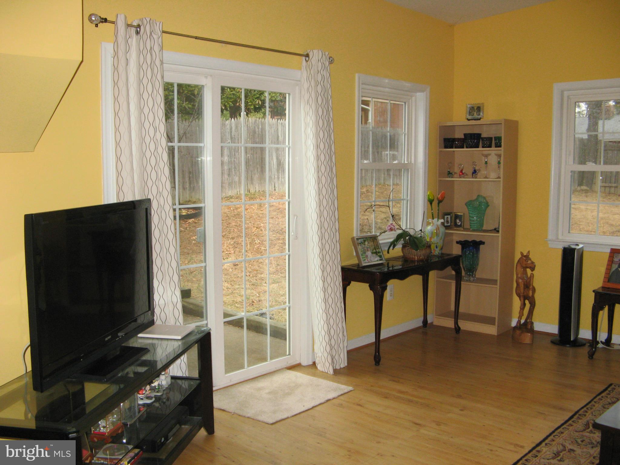7302 Old Keene Mill Road Springfield, VA 22150 - Photo 14 of 28 a living room with furniture a flat screen tv and a floor to ceiling window