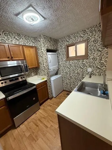 a kitchen with granite countertop a sink a stove and refrigerator