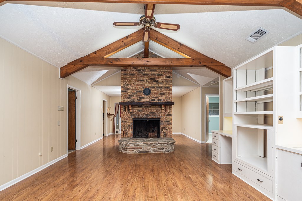110 Sierra Road Kerrville, TX 78028 - Photo 3 of 31 a living room with a fireplace and wooden floor