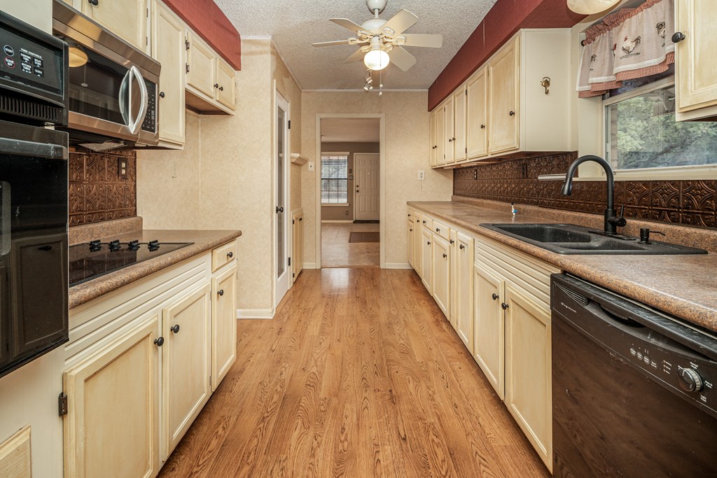 110 Sierra Road Kerrville, TX 78028 - Photo 5 of 31 a kitchen with stainless steel appliances a sink dishwasher stove refrigerator and cabinets