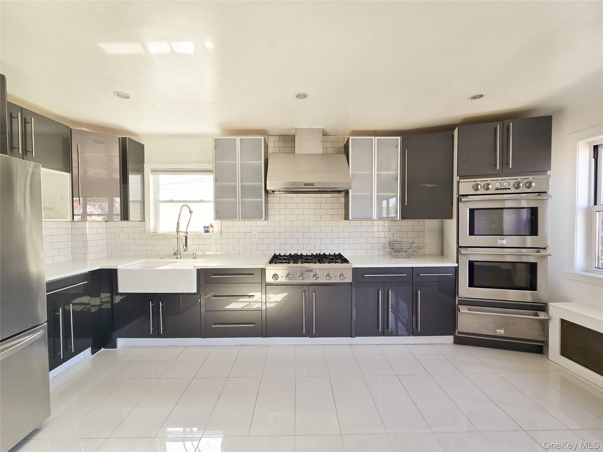 Kitchen featuring appliances with stainless steel finishes, tasteful backsplash, plenty of natural light, a warming drawer, and recessed lighting
