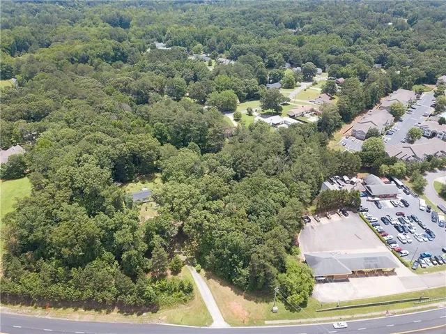 an aerial view of a house with a yard and large trees