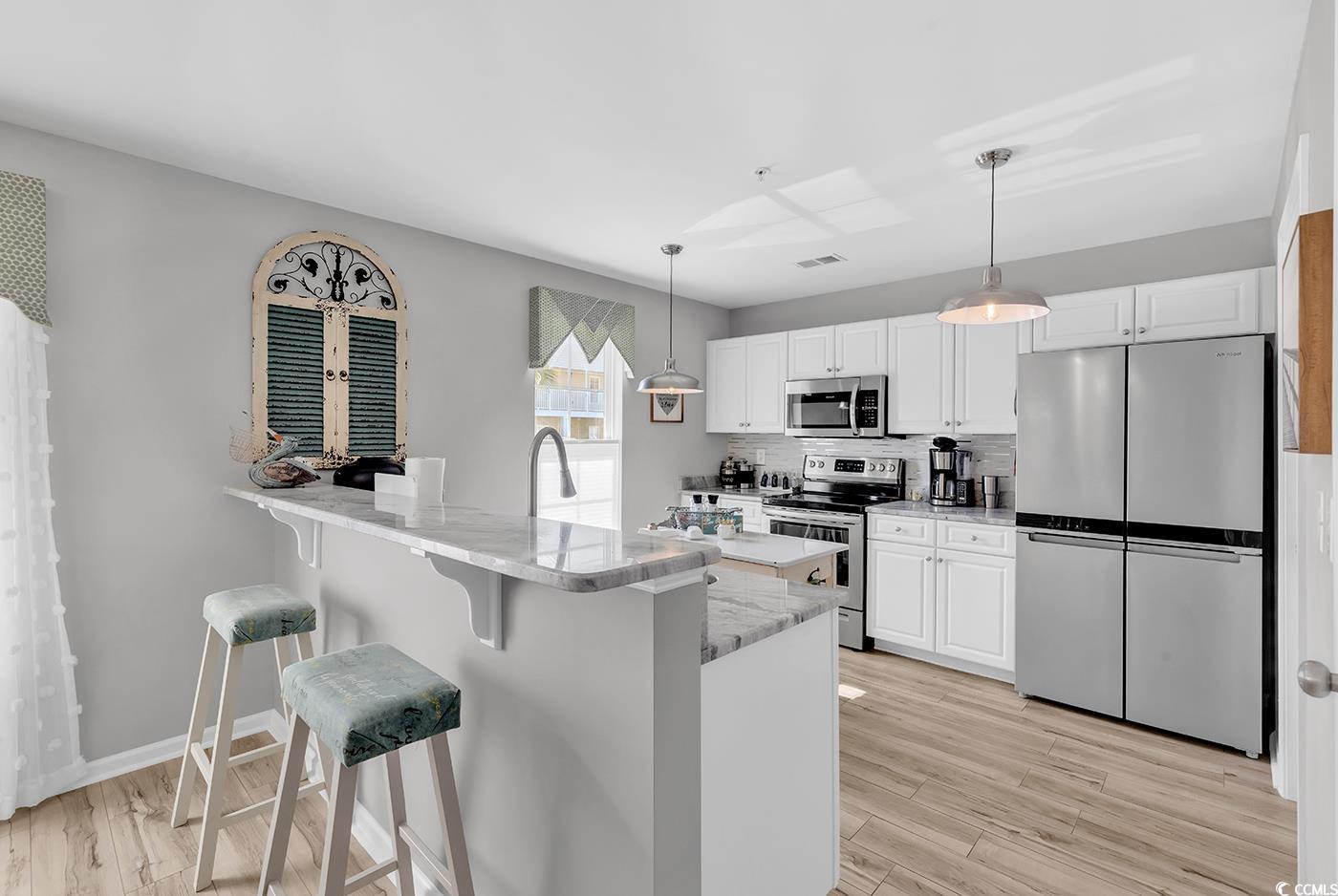 117 Butkus Drive, Unit 2 Myrtle Beach, SC 29588 - Photo 11 of 39 Kitchen featuring decorative backsplash, appliances with stainless steel finishes, and white cabinets
