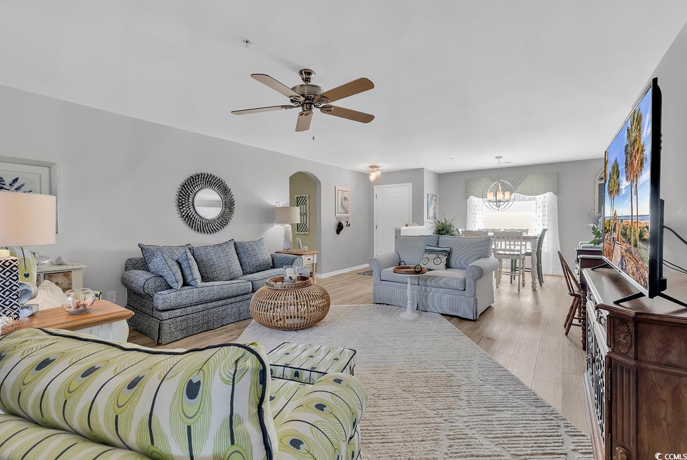 117 Butkus Drive, Unit 2 Myrtle Beach, SC 29588 - Photo 7 of 39 Living area with arched walkways, wood finished floors, and a ceiling fan