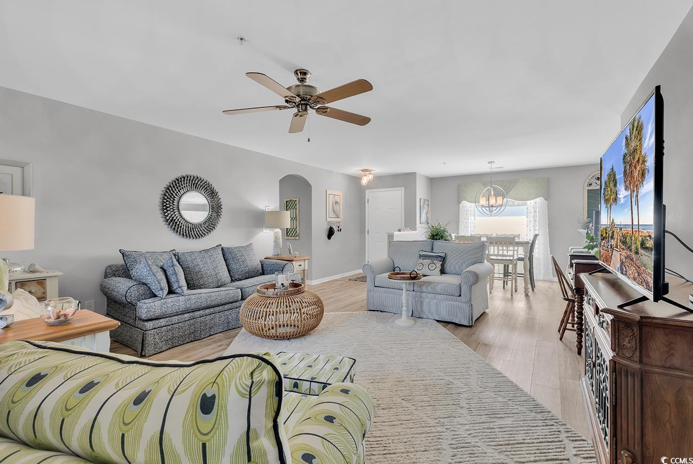 117 Butkus Drive, Unit 2 Myrtle Beach, SC 29588 - Photo 10 of 39 Living area featuring wood finished floors, arched walkways, a ceiling fan, and a chandelier