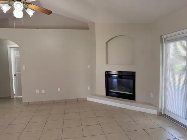 a view of an empty room with window and fire place