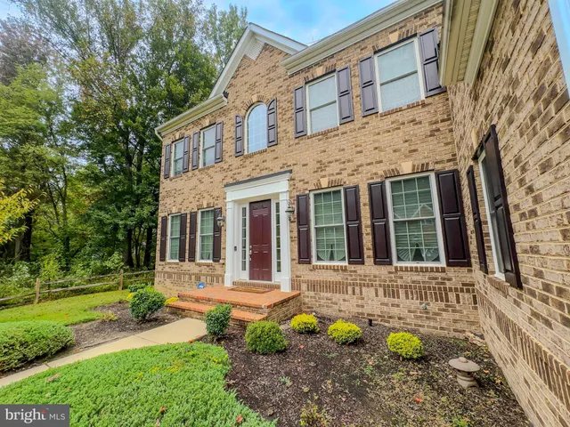 front view of a brick house with a yard table and chairs