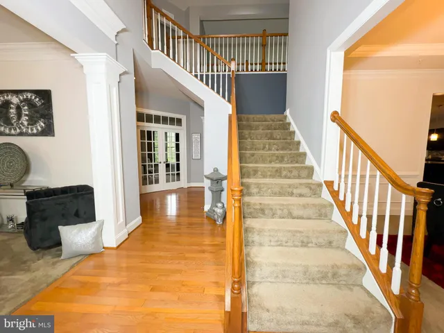 a view of staircase with lots of frames on wall and a window