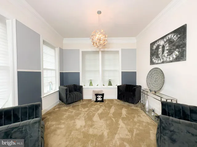 a living room with furniture a chandelier and a large window