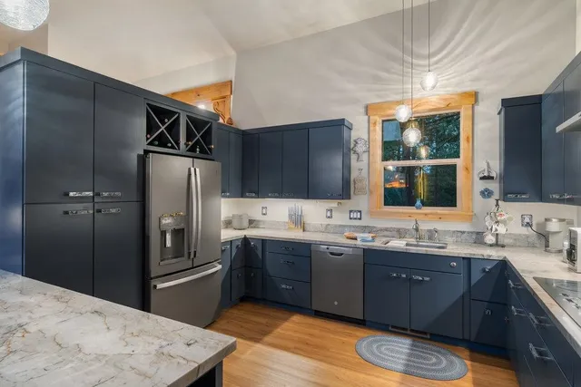 a kitchen with stainless steel appliances kitchen island granite countertop a sink stove and refrigerator