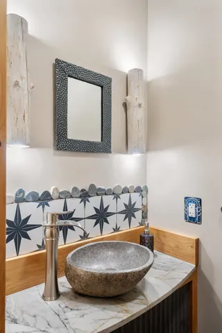 a bathroom with a granite countertop sink and a mirror