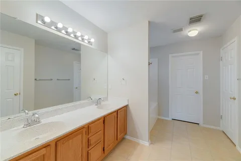 a spacious bathroom with a double vanity sink and a mirror