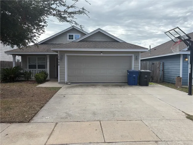 a front view of a house with a yard and potted plants