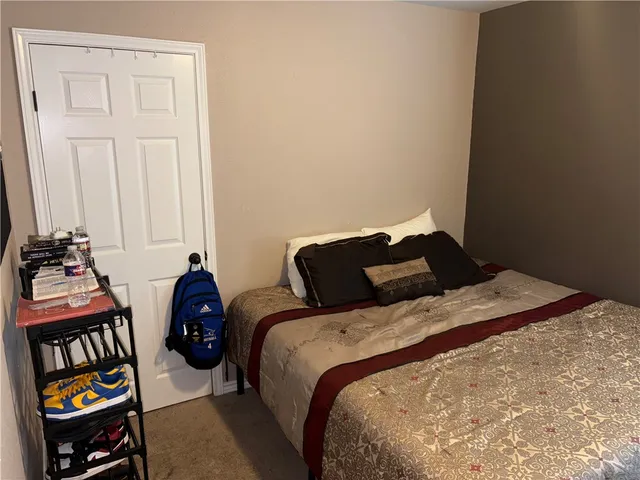 a bedroom with a bed and a painting on the wall