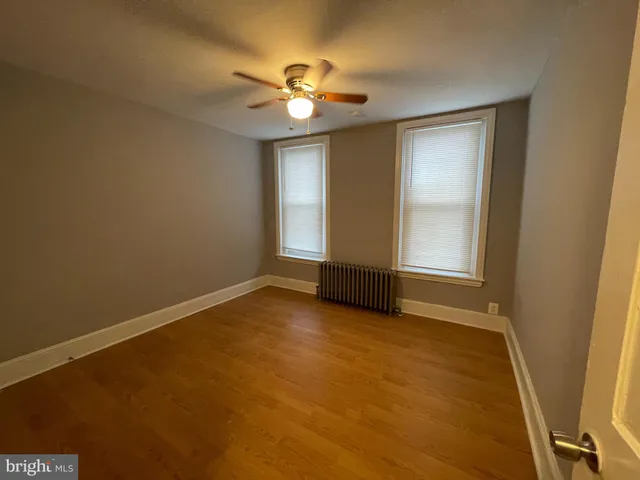 a view of an empty room with a chandelier fan