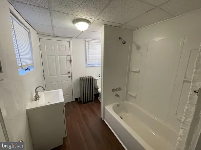 a bathroom with a tub a sink and a shower