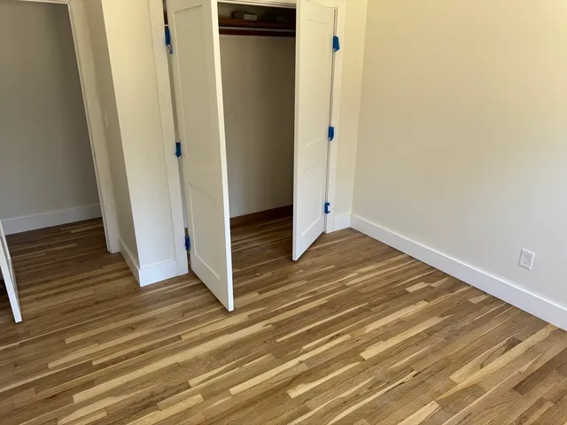 a view of a hallway with wooden floor and entryway