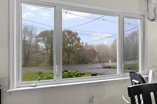 a view of a room with a large window and wooden floor