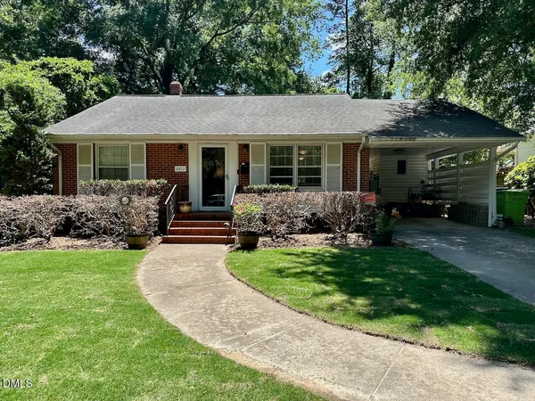 a front view of a house with a garden and yard