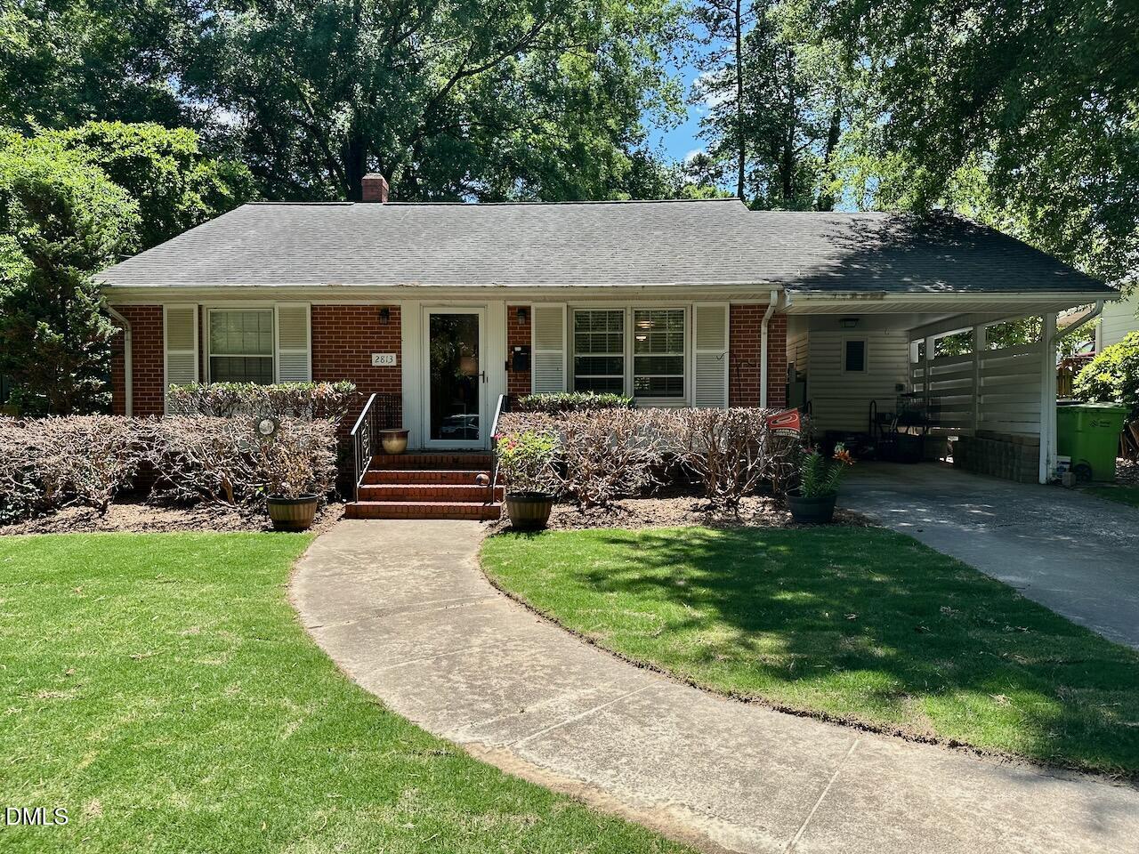 a front view of a house with a garden and yard